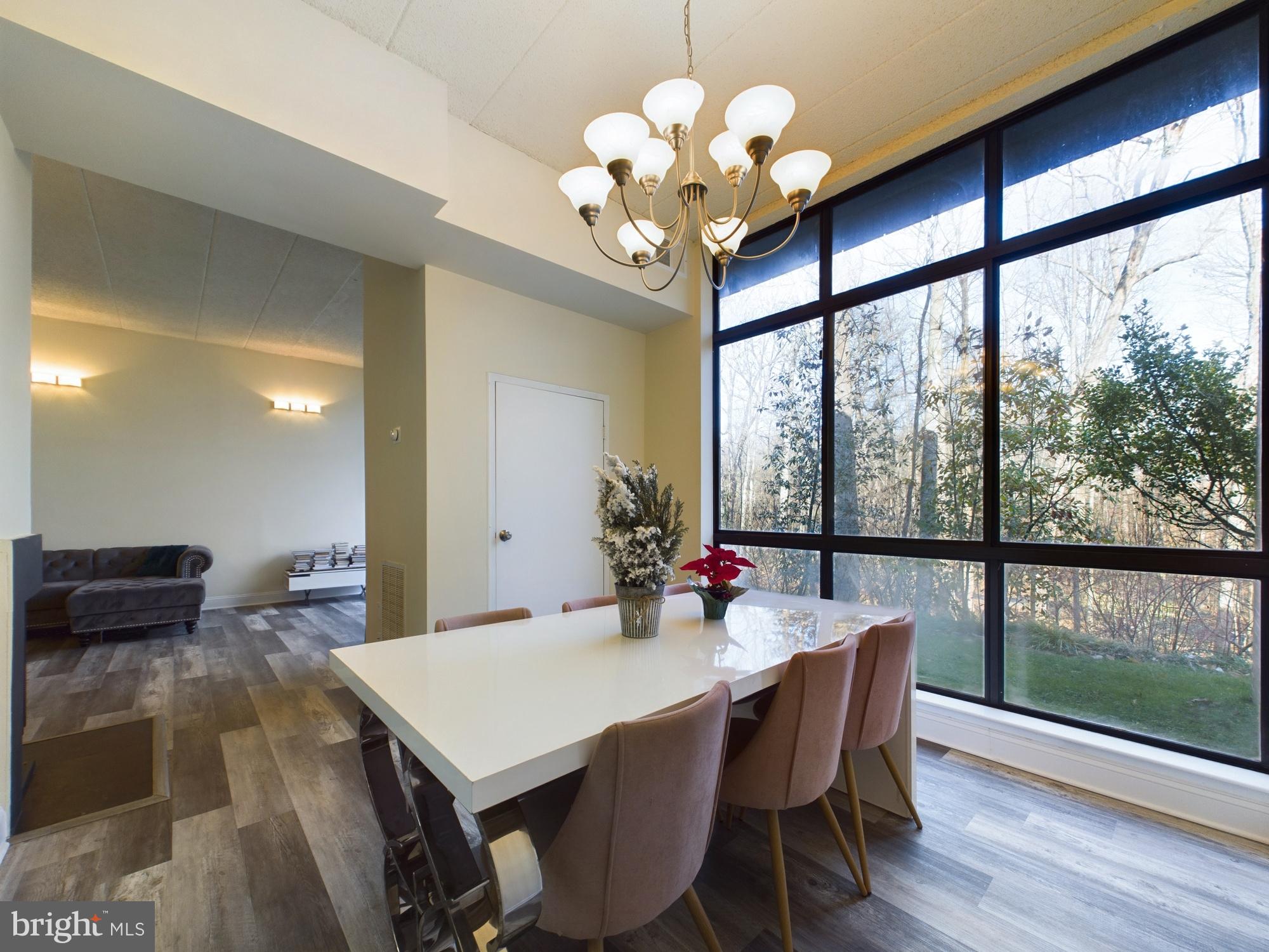 11566 Rolling Green Court, Unit 101 Reston, VA 20191 - Photo 16 of 38 a view of a dining room with furniture a chandelier and wooden floor