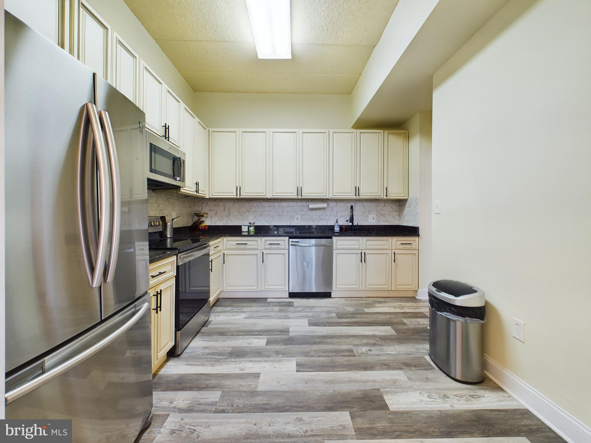 11566 Rolling Green Court, Unit 101 Reston, VA 20191 - Photo 17 of 38 a kitchen with stainless steel appliances granite countertop a refrigerator and a sink
