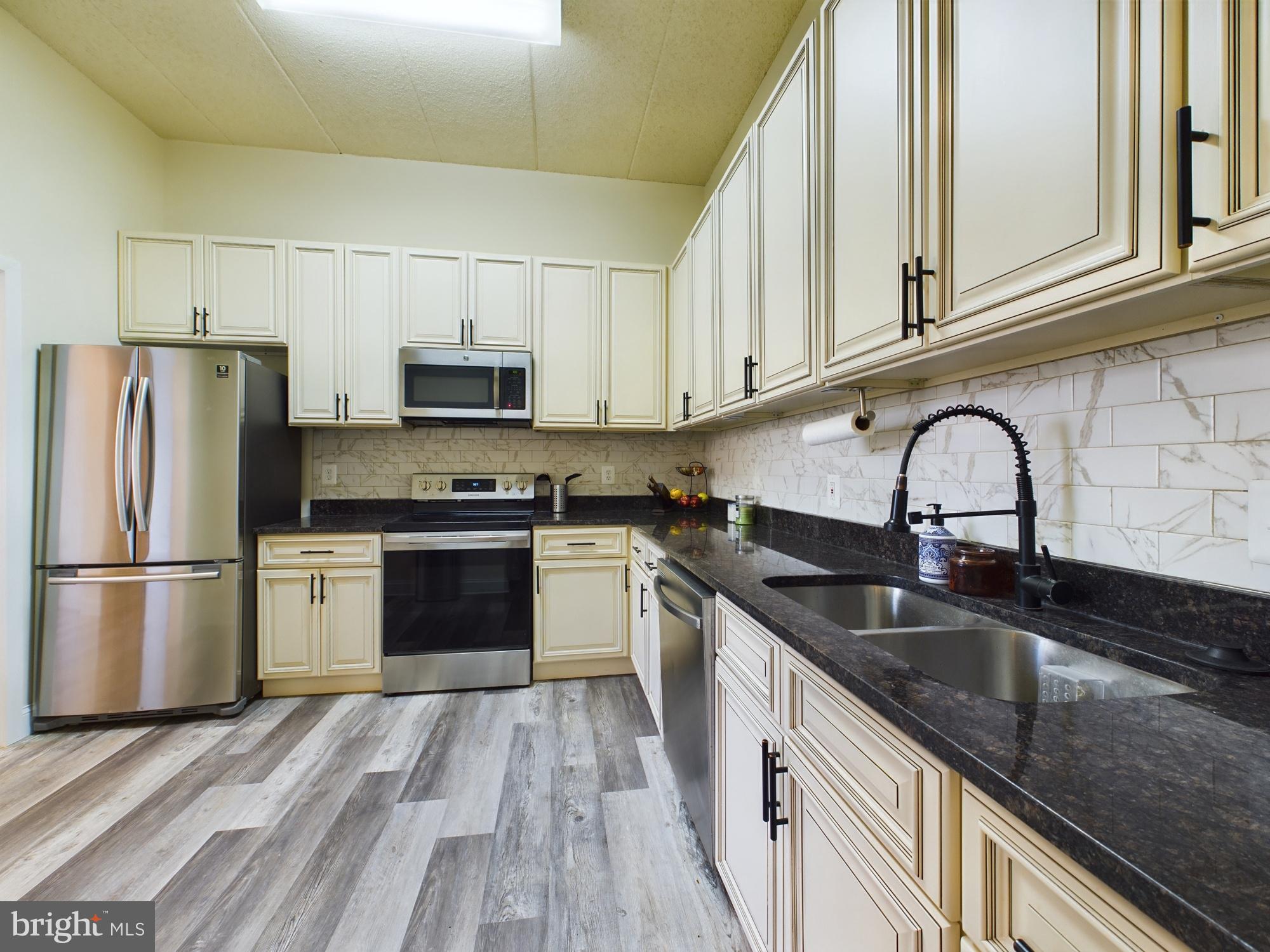 11566 Rolling Green Court, Unit 101 Reston, VA 20191 - Photo 18 of 38 a kitchen with granite countertop a refrigerator and a sink