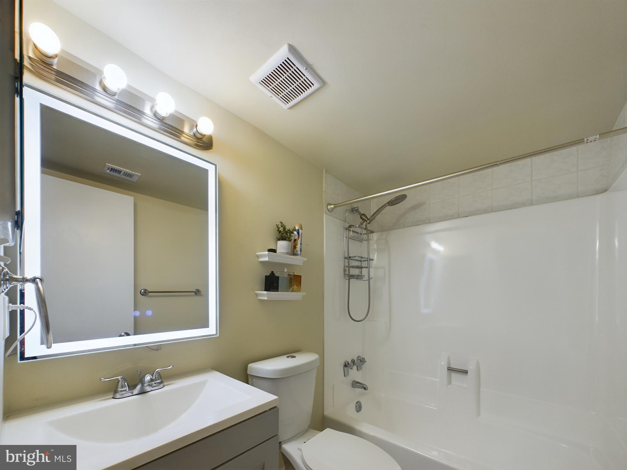 11566 Rolling Green Court, Unit 101 Reston, VA 20191 - Photo 23 of 38 a bathroom with a sink mirror toilet and shower