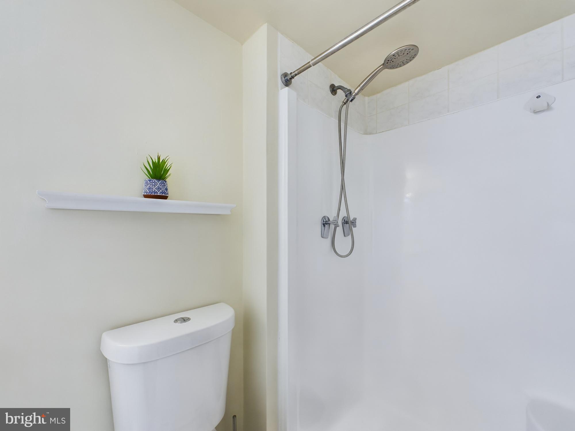 11566 Rolling Green Court, Unit 101 Reston, VA 20191 - Photo 30 of 38 a bathroom with a shower a toilet and a shower