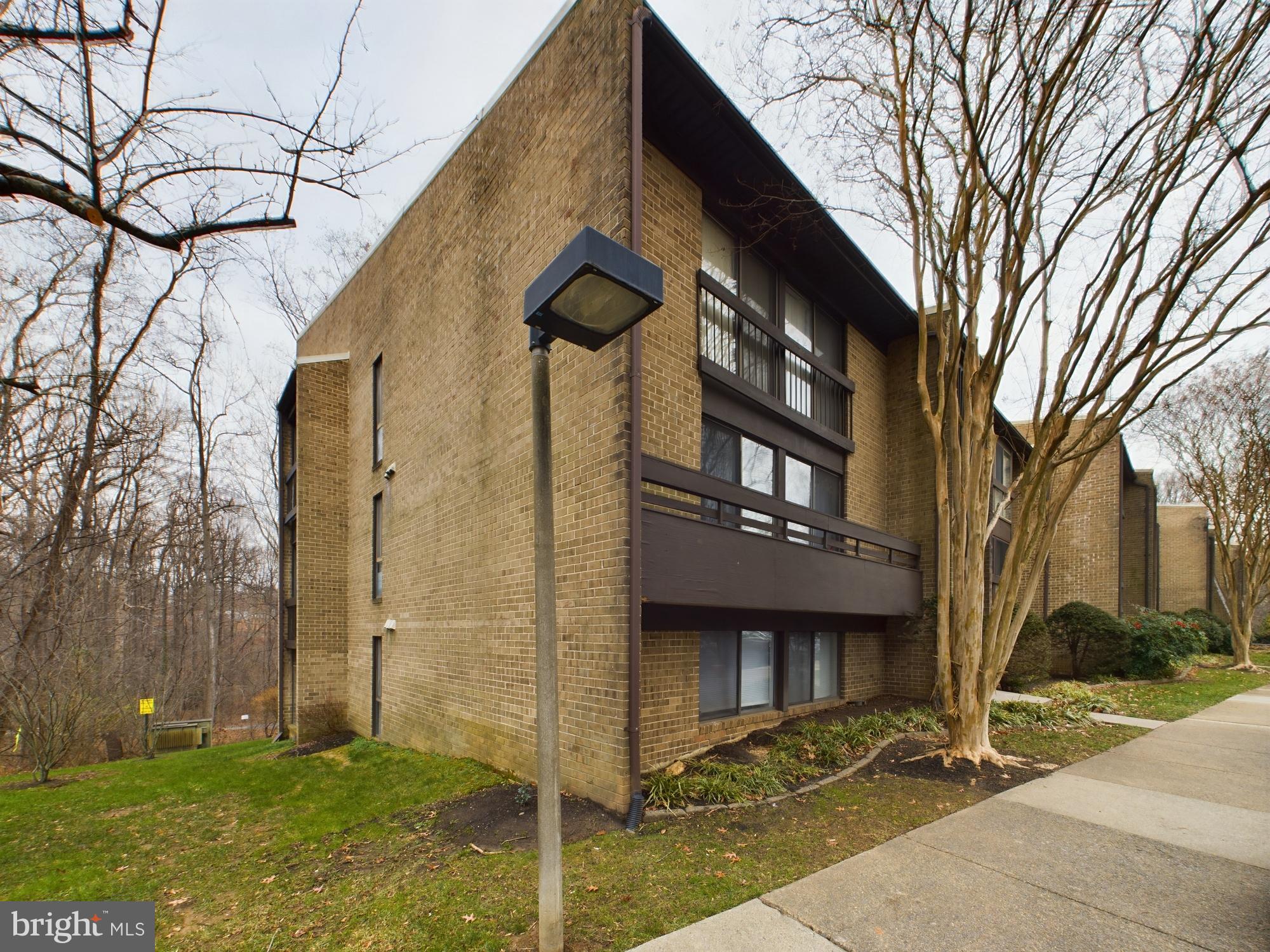11566 Rolling Green Court, Unit 101 Reston, VA 20191 - Photo 36 of 38 a brick building with a tree in front of it