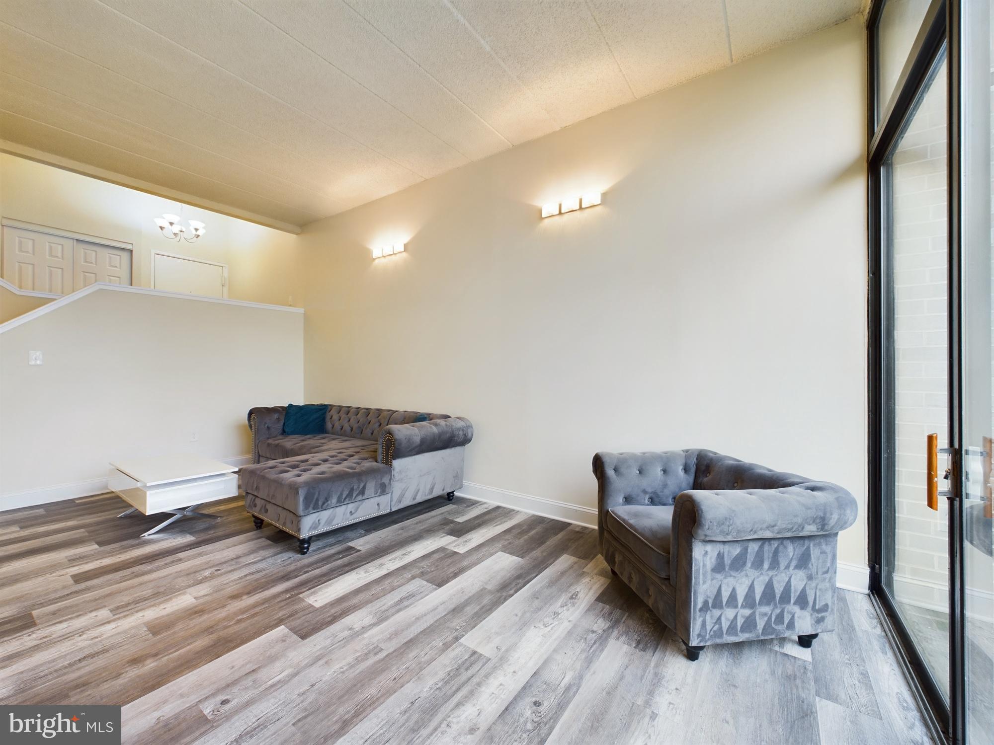 11566 Rolling Green Court, Unit 101 Reston, VA 20191 - Photo 4 of 38 a living room with furniture and a wooden floor