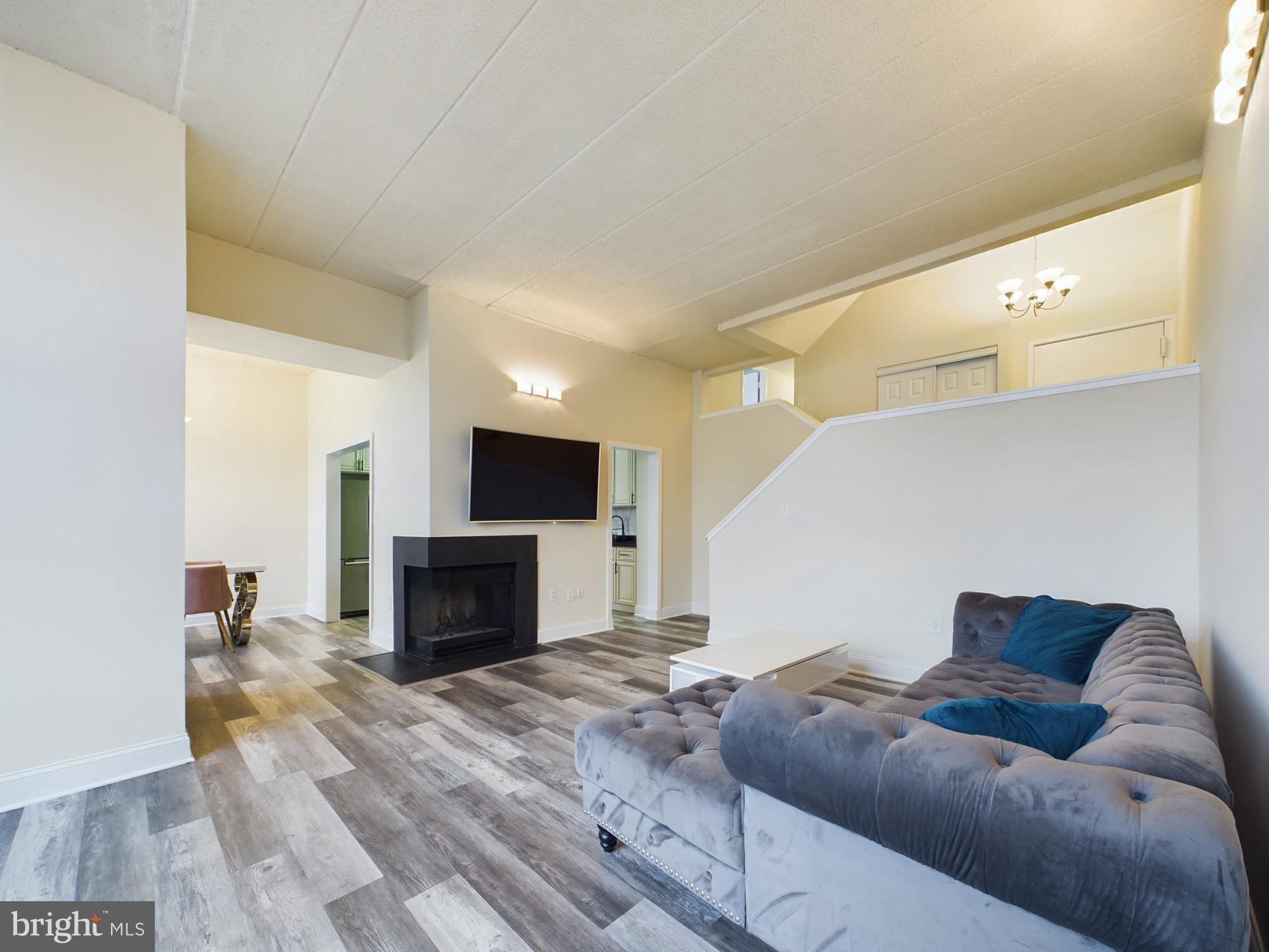 11566 Rolling Green Court, Unit 101 Reston, VA 20191 - Photo 5 of 38 a living room with furniture and a fireplace