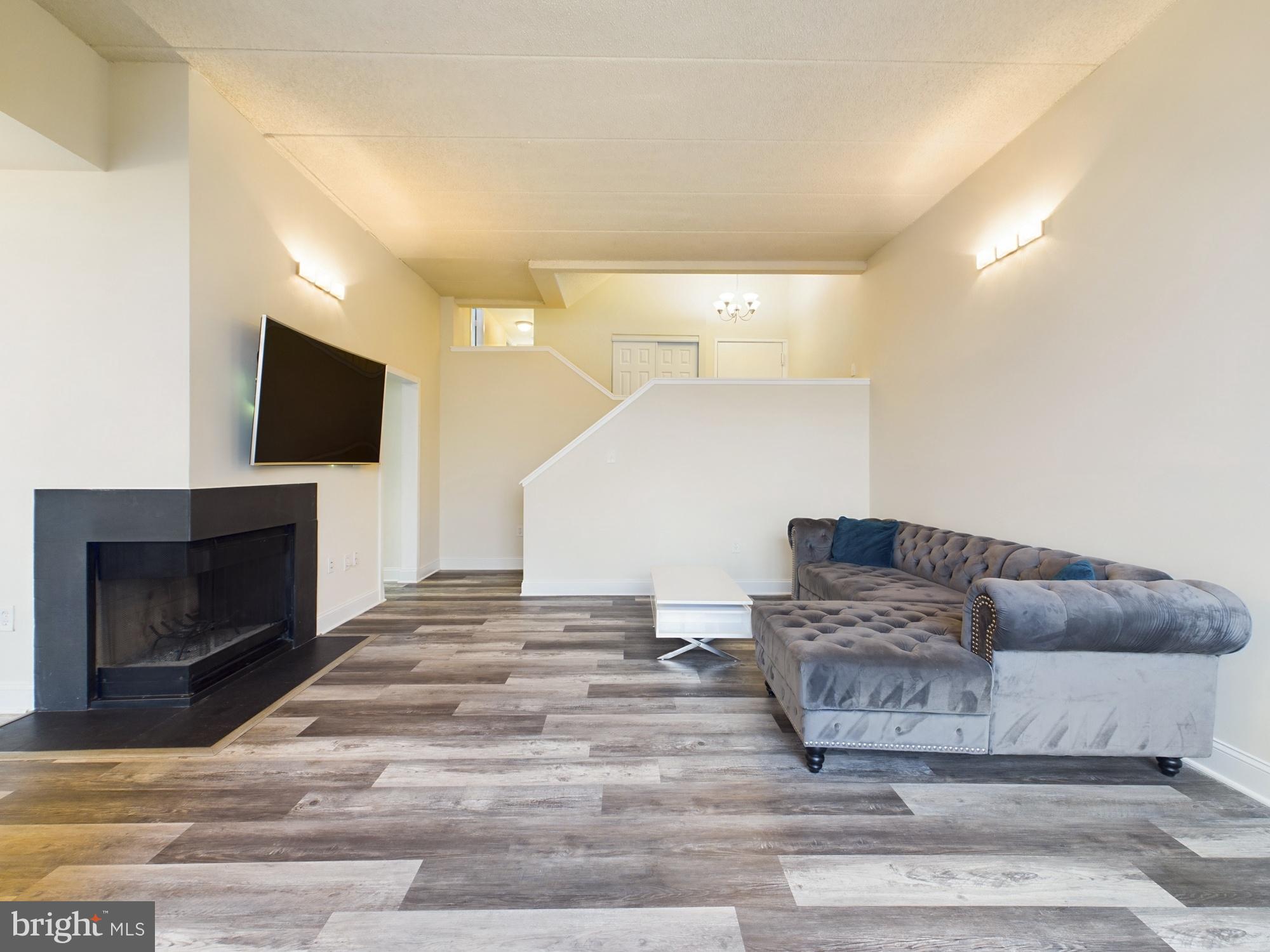 11566 Rolling Green Court, Unit 101 Reston, VA 20191 - Photo 6 of 38 a living room with furniture and a fireplace