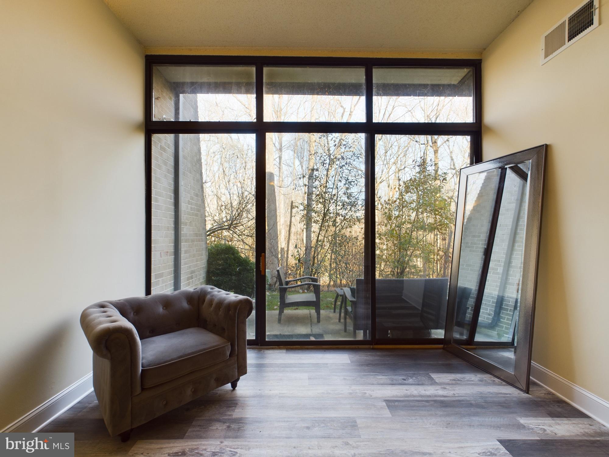 11566 Rolling Green Court, Unit 101 Reston, VA 20191 - Photo 7 of 38 a living room with furniture and a floor to ceiling window