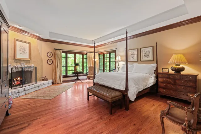 a bedroom with a bed a fireplace and a large window