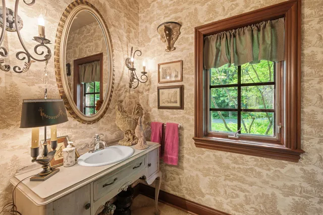 a bathroom with a sink a mirror and a window