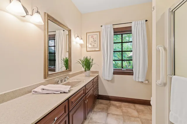 a bathroom with a granite countertop sink and a window