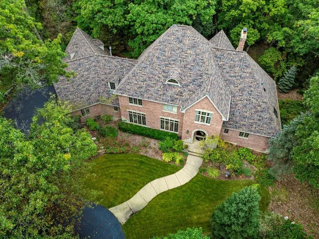 a view of a house with a small yard plants and large tree