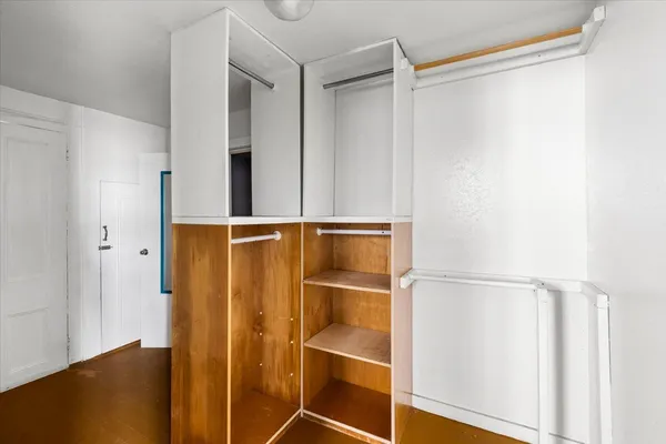 a view of walk in closet with empty racks
