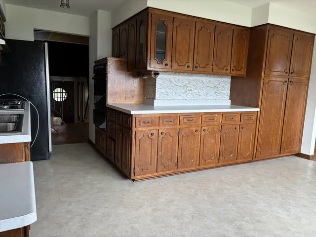 a kitchen with stainless steel appliances a refrigerator and a stove top oven
