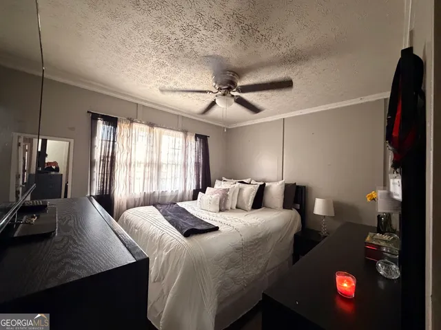 a bedroom with a bed and a tv on the dresser