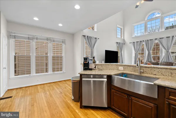 a view of a kitchen with stainless steel appliances granite countertop a sink and a stove
