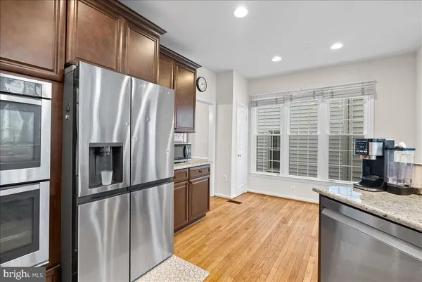 a kitchen with stainless steel appliances granite countertop a refrigerator and a sink