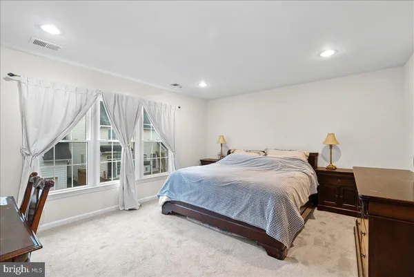 a spacious bedroom with a bed a table and a large window