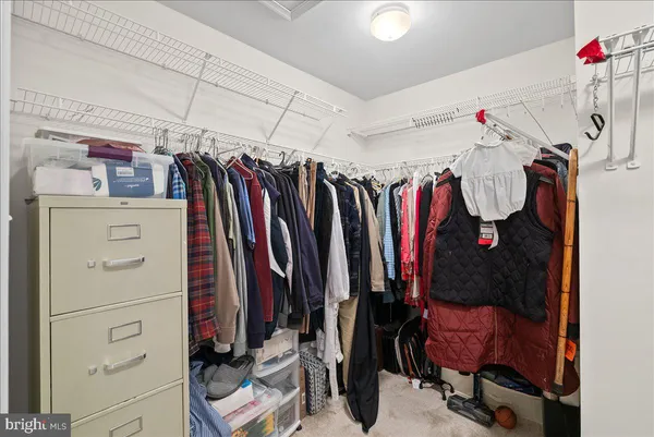 a view of walk in closet with clothes