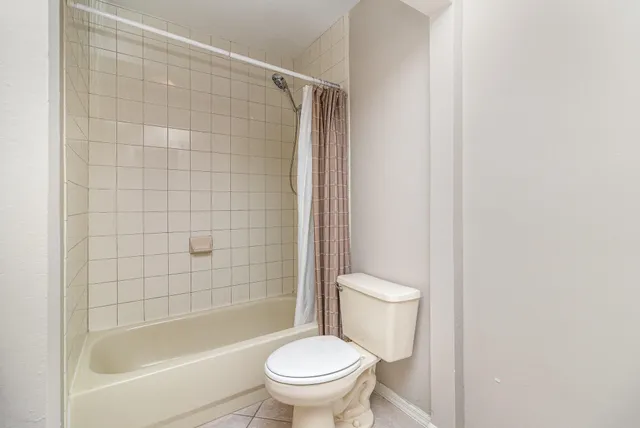 a white toilet sitting next to a bath tub