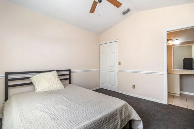 a bedroom with a bed and a ceiling fan