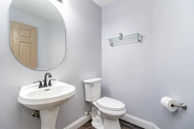 a bathroom with a toilet a sink and mirror