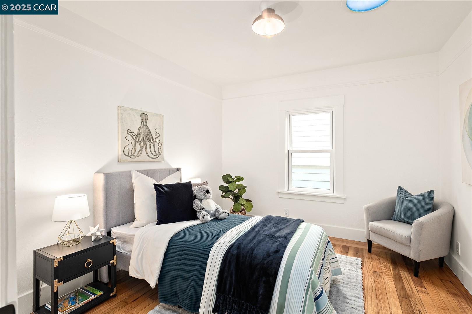1233 Haskell Street Berkeley, CA 94702 - Photo 14 of 24 a bedroom with a bed and wooden floor
