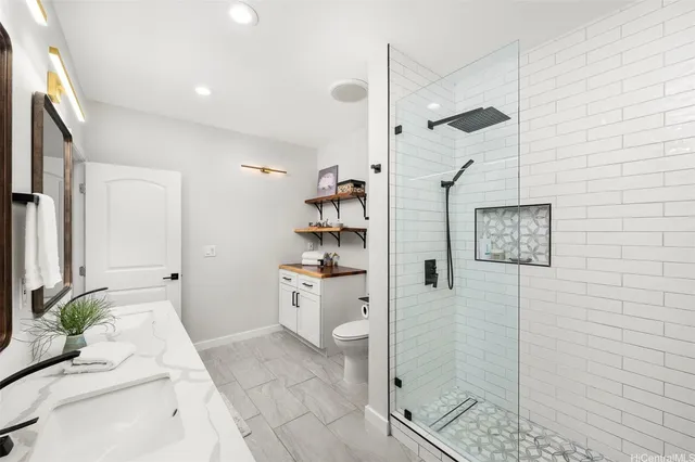 a bathroom with a granite countertop sink a toilet and shower