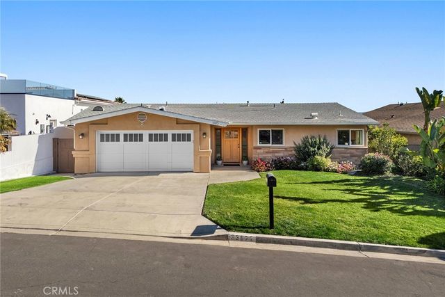 a front view of a house with a garden and plants