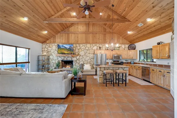 a living room with stainless steel appliances kitchen island granite countertop lots of counter top space