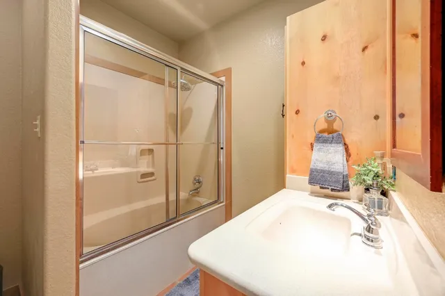 a spacious bathroom with a granite countertop sink a toilet a mirror and bathtub