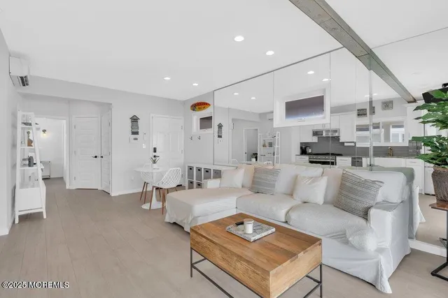 a living room with furniture and a view of kitchen