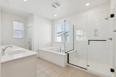 a bathroom with a tub sink shower and mirror