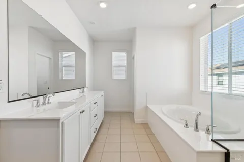 a bathroom with a tub sink and mirror