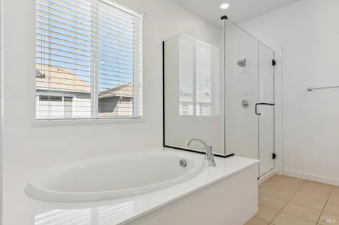 a white bath tub sitting next to a shower