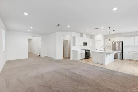 a view of a kitchen with refrigerator and white cabinets