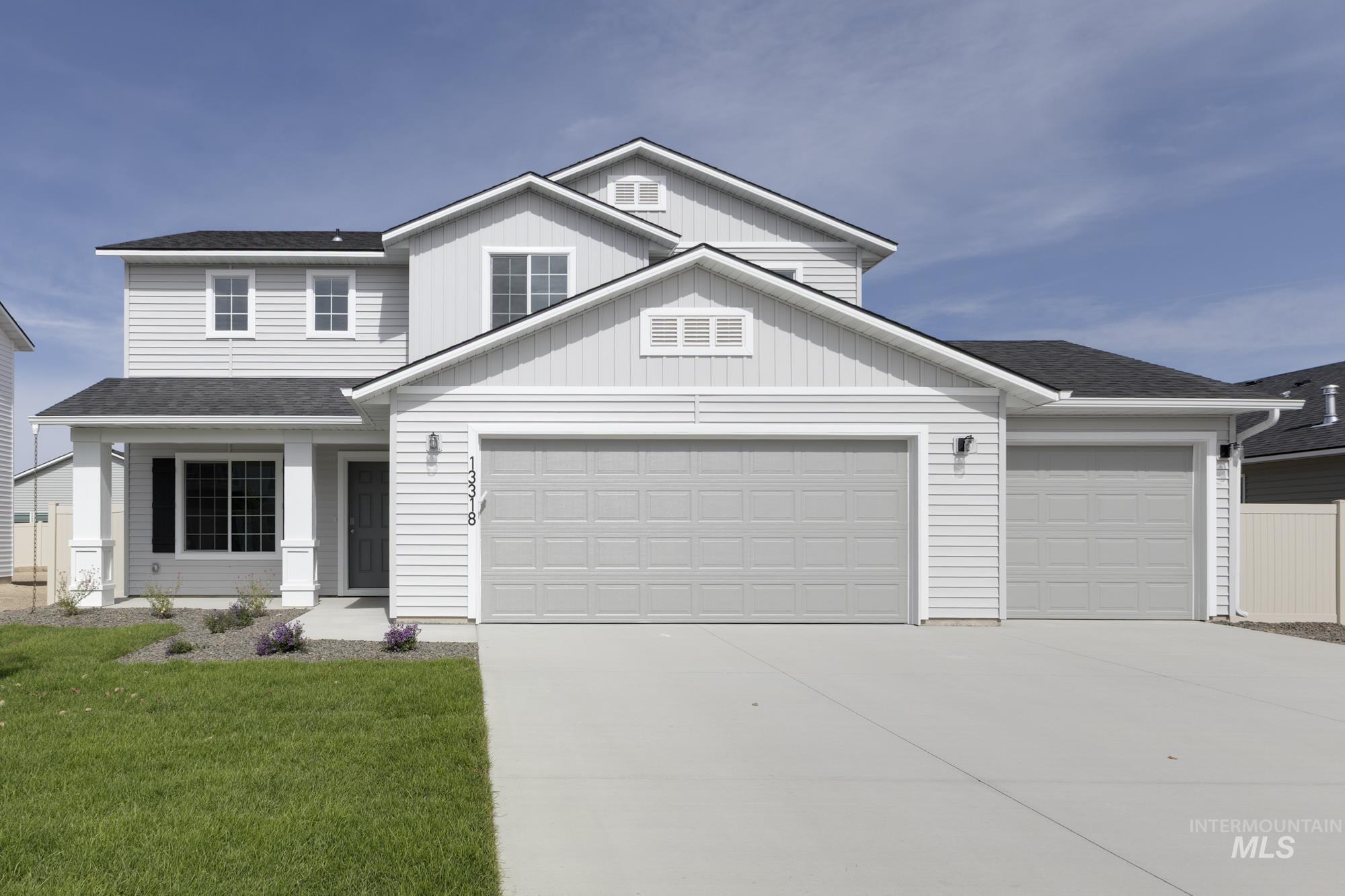 Traditional-style home with driveway, roof with shingles, a garage, and a porch
