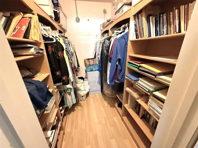 a view of walk in closet with clothes and shoes