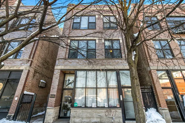 a view of a brick house with a large tree