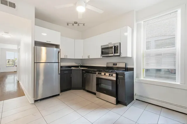 a kitchen with stainless steel appliances granite countertop a stove a microwave and a refrigerator