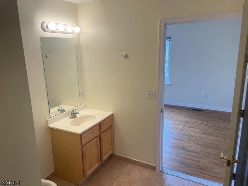 1527 Lamberts Mill Road, Unit 1A Westfield, NJ 07090 - Photo 11 of 13 a bathroom with a sink a mirror and vanity