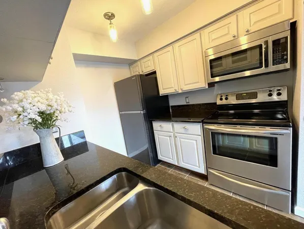a kitchen with stainless steel appliances a stove microwave and refrigerator