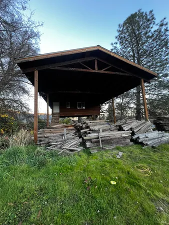 a backyard of a house with table and chairs under an umbrella