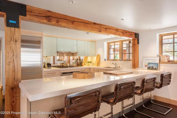 a kitchen with a sink and chairs