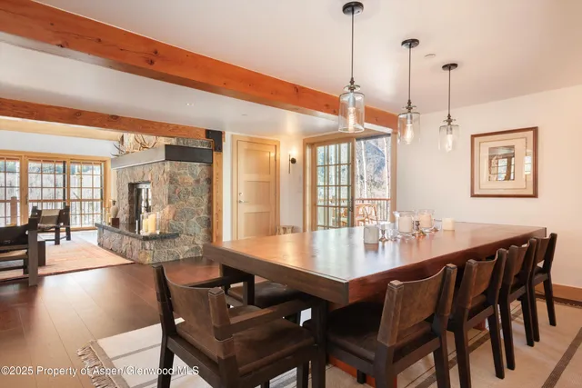 a view of a dining room and livingroom with furniture wooden floor a chandelier