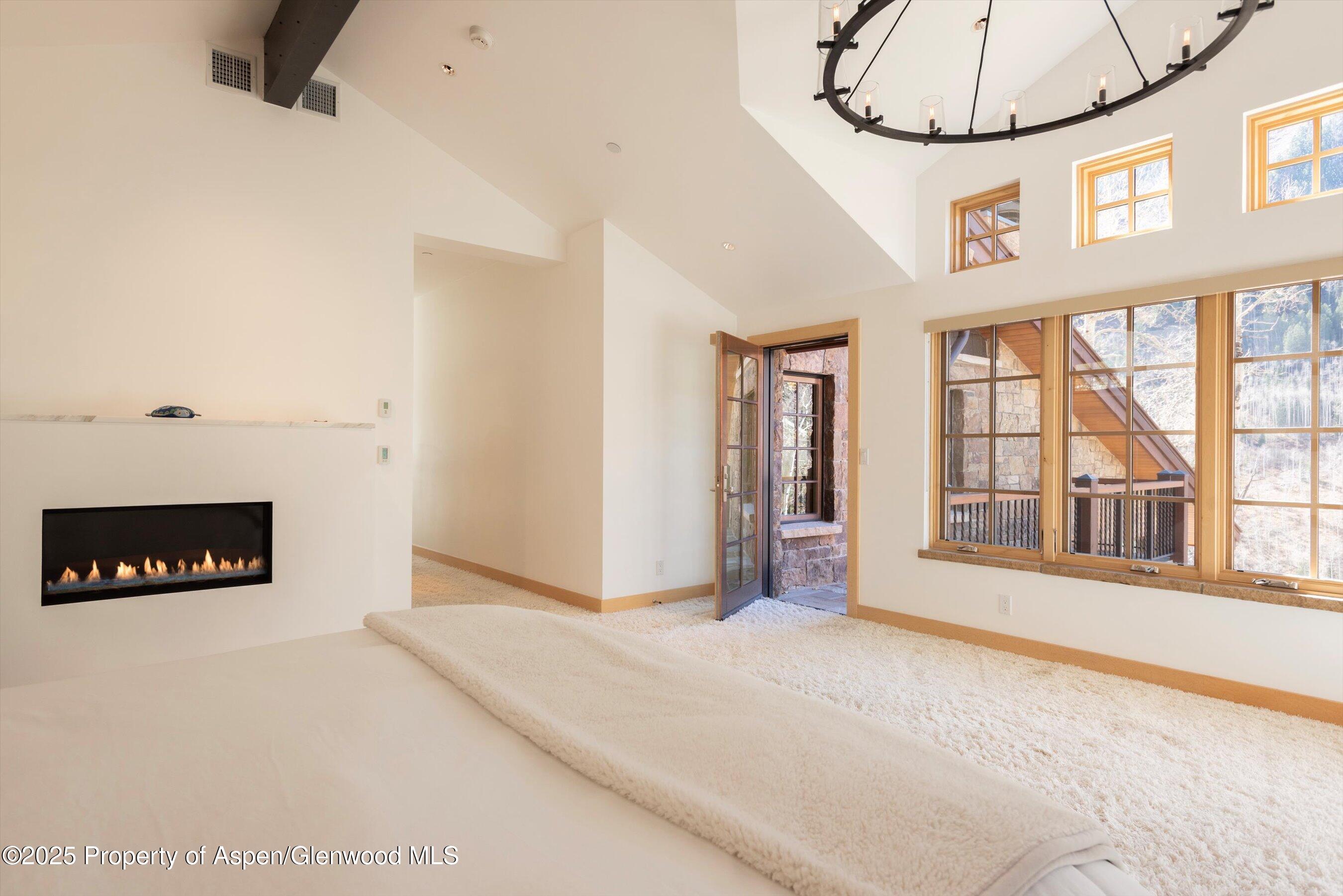 6770 Castle Creek Road Aspen, CO 81612 - Photo 16 of 53 an empty room with a large window and chandelier