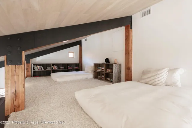 a large bed sitting in a bedroom next to a window