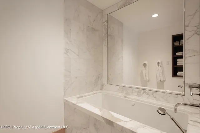 a bathroom with a tub sink and vanity