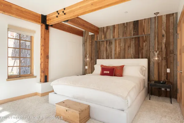 a bedroom with a bed and a flat tv screen next to a window