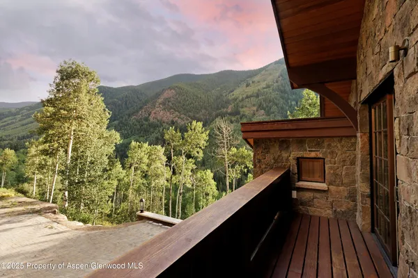 a view of a wooden chairs on the roof deck