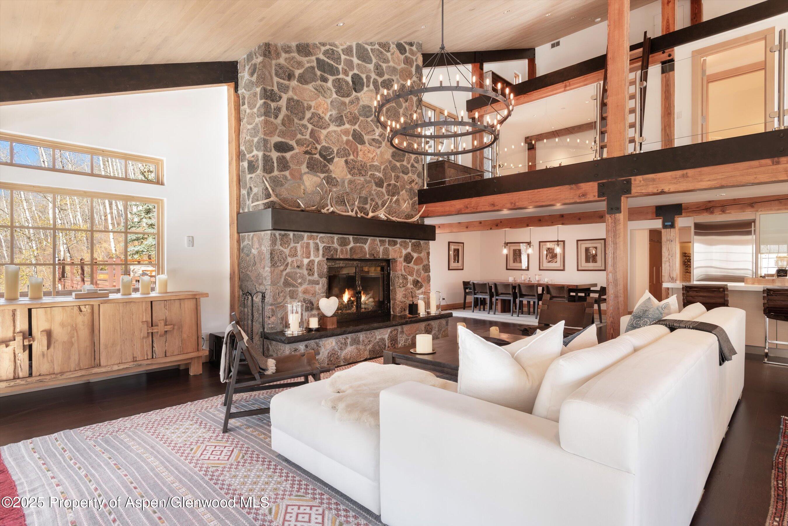 6770 Castle Creek Road Aspen, CO 81612 - Photo 5 of 53 a living room with furniture a flat screen tv and a fireplace