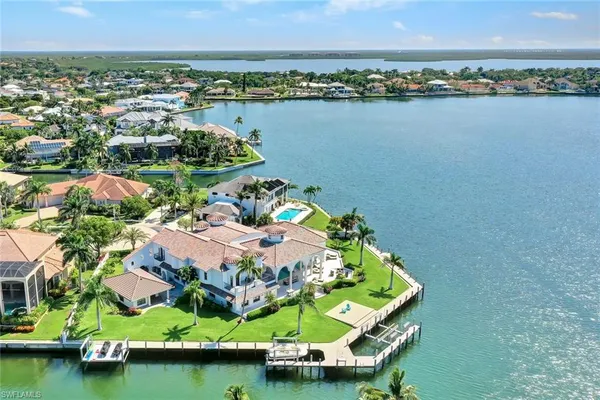 an aerial view of a house with a garden and lake view